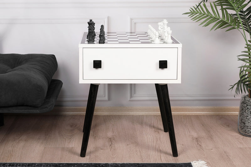 Tavolino scacchiera basso da salotto moderno in legno, quadrato con gambe alte, colori: bianco opaco e nero opaco. Cassetto frontale diviso in due scomparti e piano estraibile posteriore. Le 32 pedine per giocare sono incluse. Dimensioni cm 50x50x60h