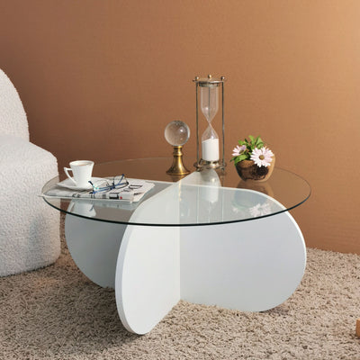 Tavolino da soggiorno basso con ripiano in vetro temperato trasparente, con gambe in legno color bianco opaco a croce rotonde. Dimensioni cm 75x75x35h