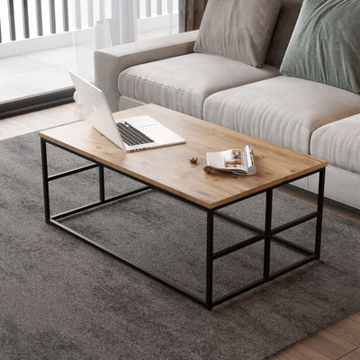 Tavolino da salotto moderno con ripiano in legno in finitura naturale opaco e struttura in metallo nero opaco con dettagli geometrici sulle gambe. Dimensioni cm 100x60x40h