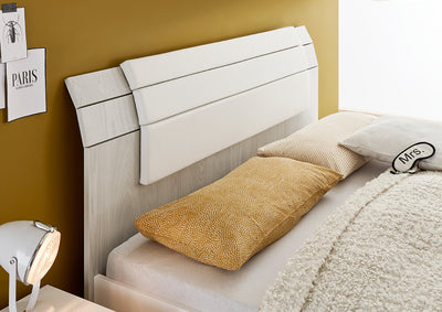 letto testiera in legno grigio artico e cuscino bianco
