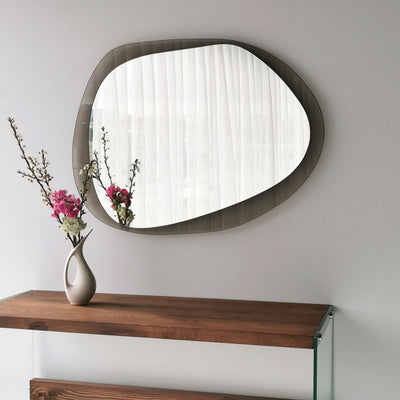 Specchio decorativo da parete moderno disegno organico con struttura in vetro temperato, disponibile sia in fumé che trasparente, da appendere al muro. Dimensioni cm 75x2x55h